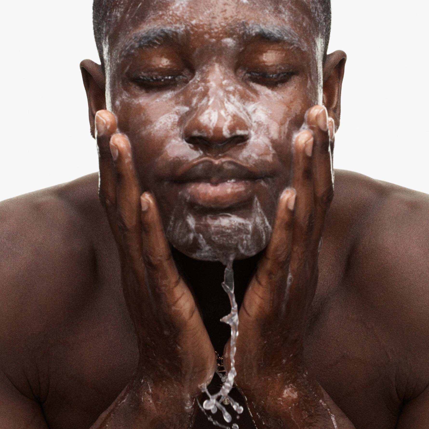 Model washing face with total cleanser. Model washing face with total cleanser.