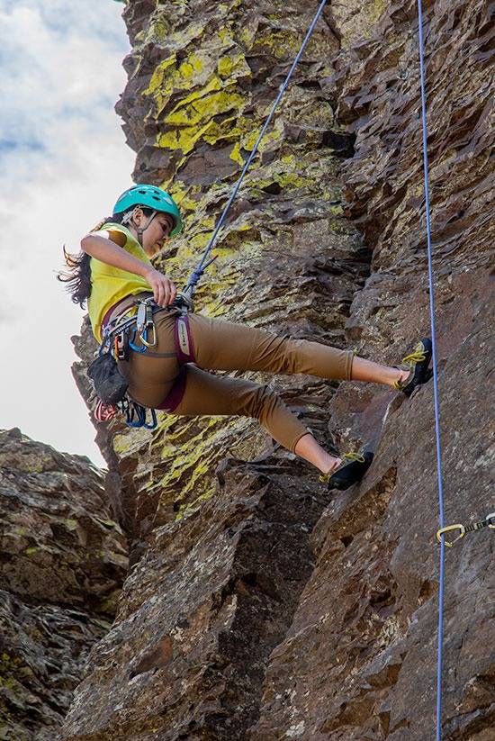 Woman rock climbing the Tinkham Pant by Beyond Clothing.