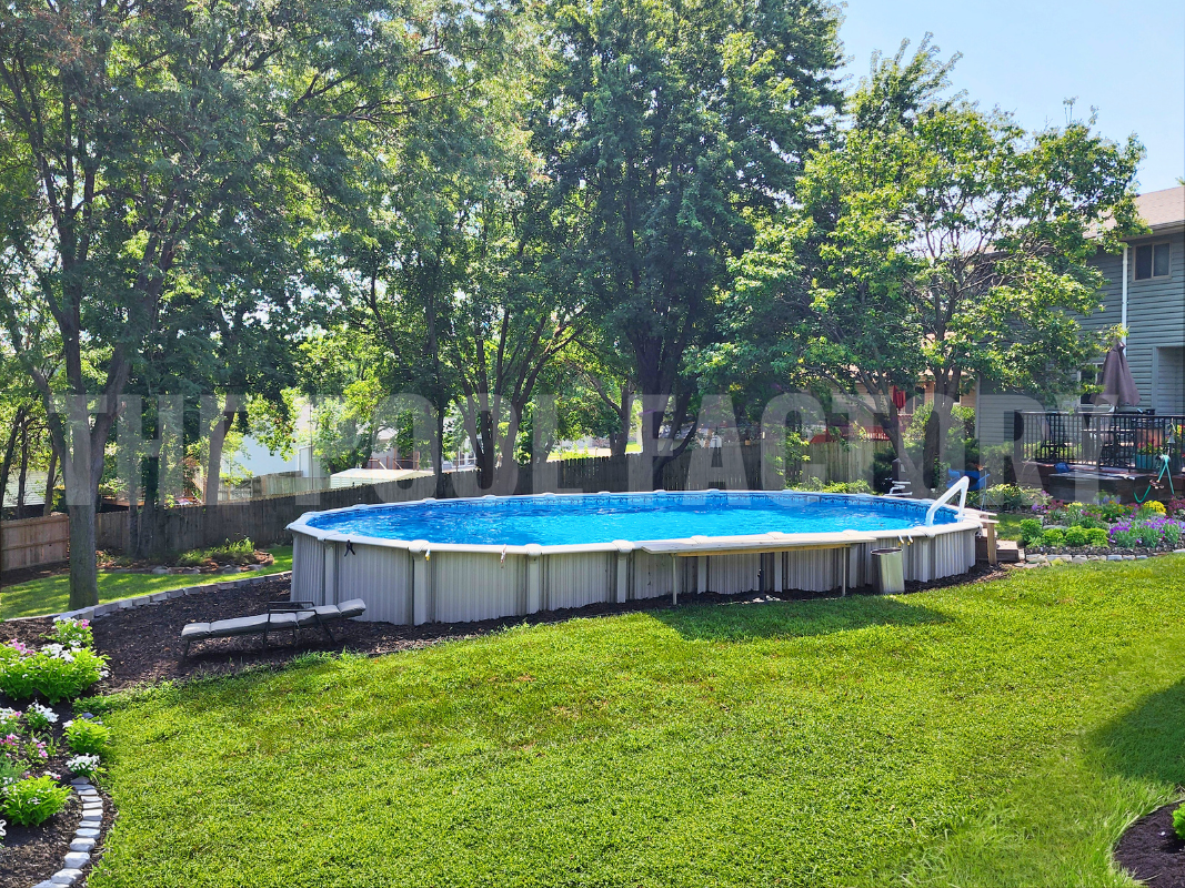 Above ground oval swimming pool with garden landscaping on a sunny day