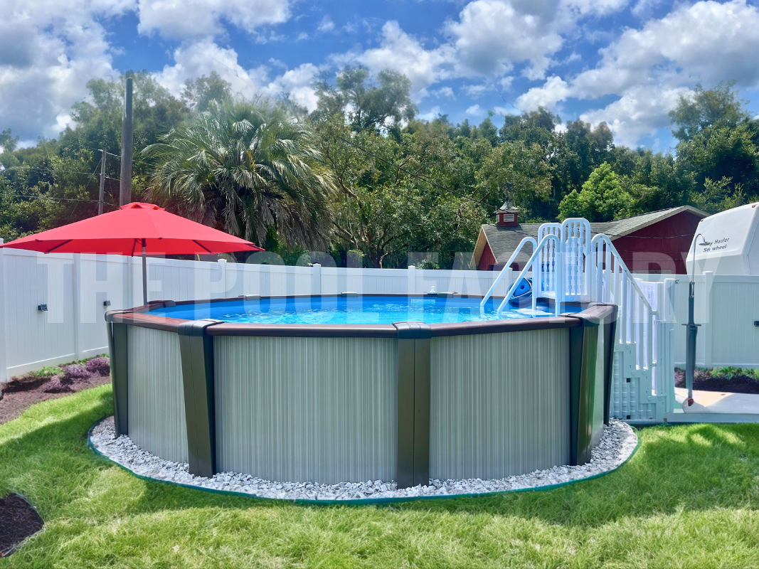Round above ground pool surrounded by neatly cut grass and palm trees