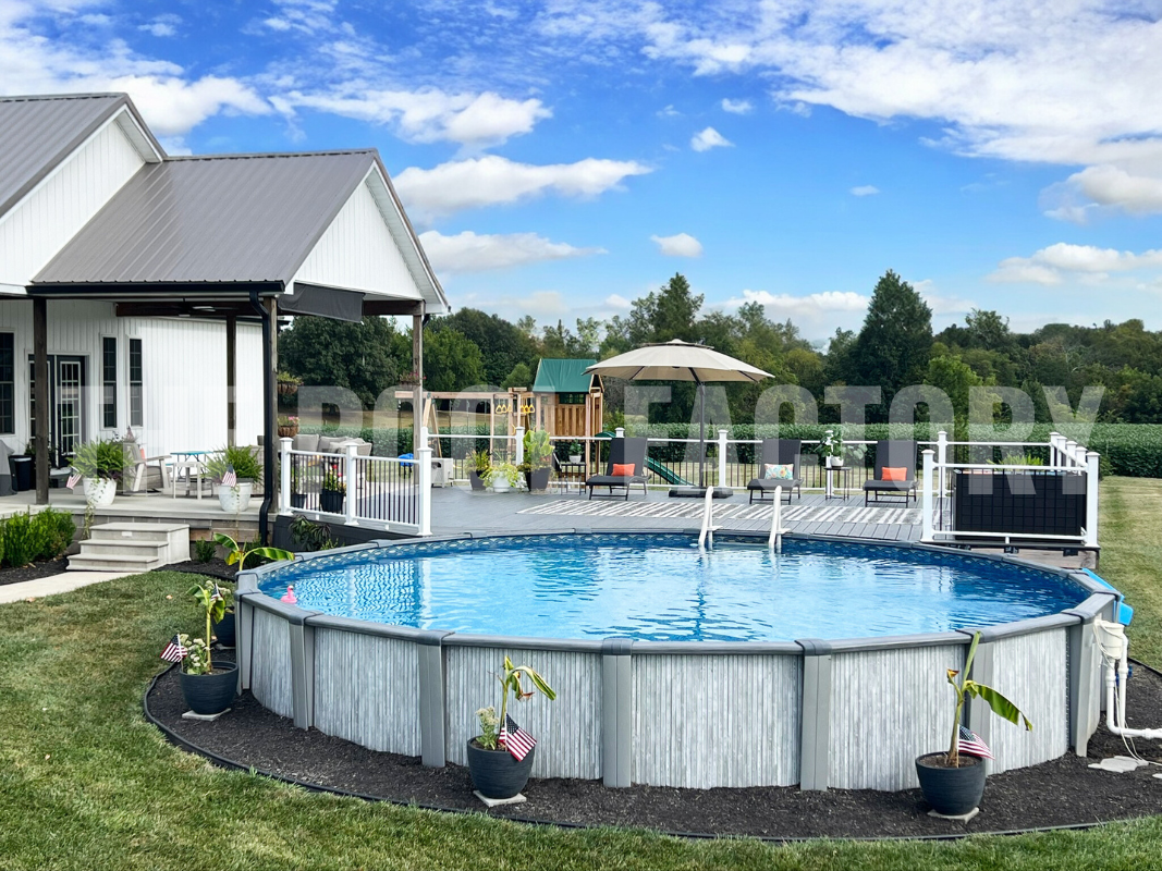 Round above ground swimming pool with deck surrounded by lush greenery and tall trees