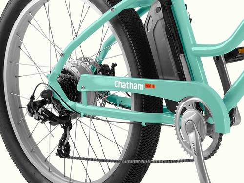 Close-up of a teal ebike's rear wheel, gears, and pedal, with visible battery pack.