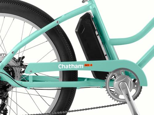 Close-up of a teal bike chain guard with an ebike battery attached.