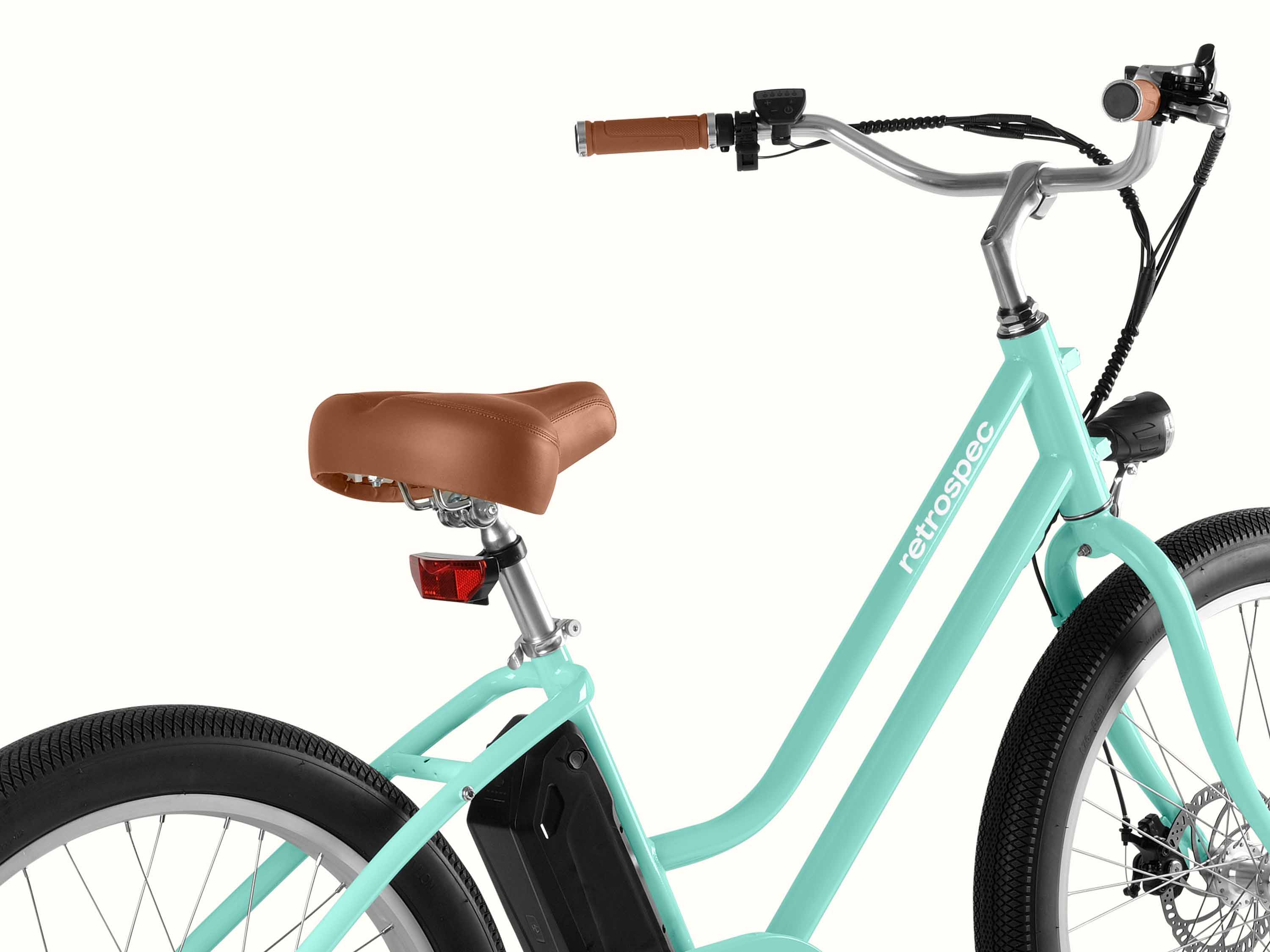 A mint green bicycle with a brown seat and handles, and the brand 