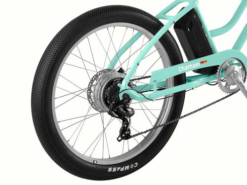 Close-up of a teal electric bicycle's rear wheel with a focus on chain and gear mechanism.