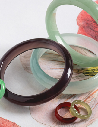 A close up of an assortment of colorful jade stone jewelry