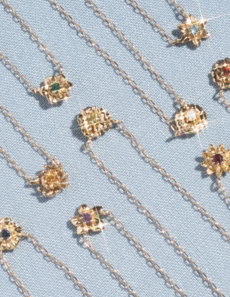 A close up of three gold gemstone rings laying on a black background