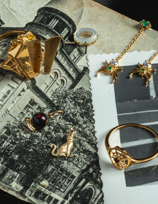 Halloween inspired jewelry laying on vintage Halloween postcards
