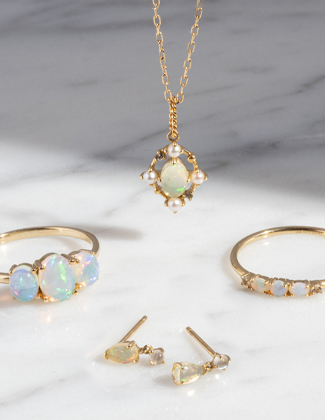 Two gold rings, a gold necklace, and gold earrings with opal gemstones