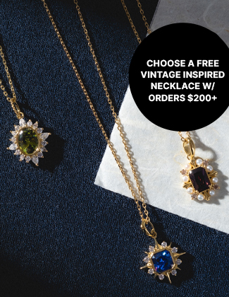 three gold and gemstone pendant necklaces on a black and withe back ground. Text reads choose a free vintage inspired necklace w/ orders $200+
