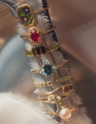 Three gold gemstone rings laying on a black background