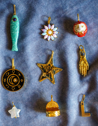 Assorted gold charms laying on light blue velvet fabric with a badge that reads 20% off