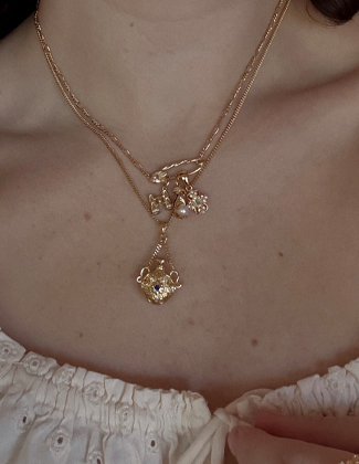 Close up of a gold necklace stack on a woman wearing an eyelet tank top