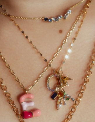 Close up of a woman wearing three gold layered necklaces