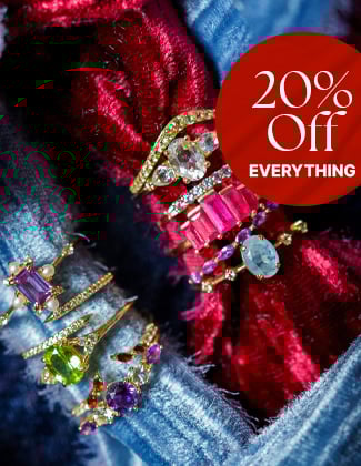 Gold gemstone rings laying on blue and red crished velvet fabric with a badge that reads 20% off