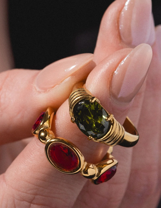 Close up of two gemstone rings on a finger