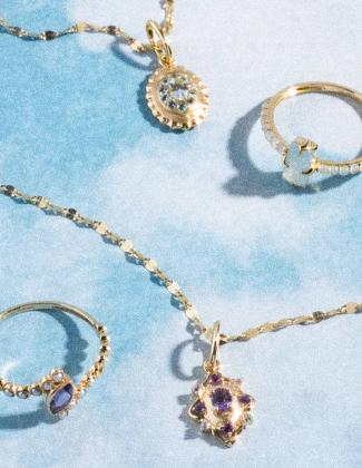 Blue and purple gemstone jewelry laying on a light blue background