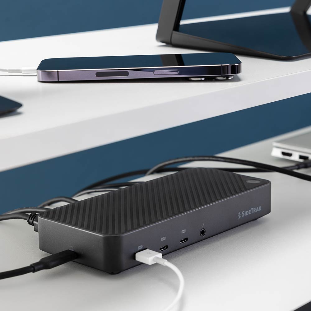 13 Port  Docking Station  SideTrak  13-Port Docking Station Hub  The SideTrak docking station is elegantly positioned next to a smartphone, showcasing its slim design and efficient charging capabilities, perfect for tech-savvy professionals and multitasking.
