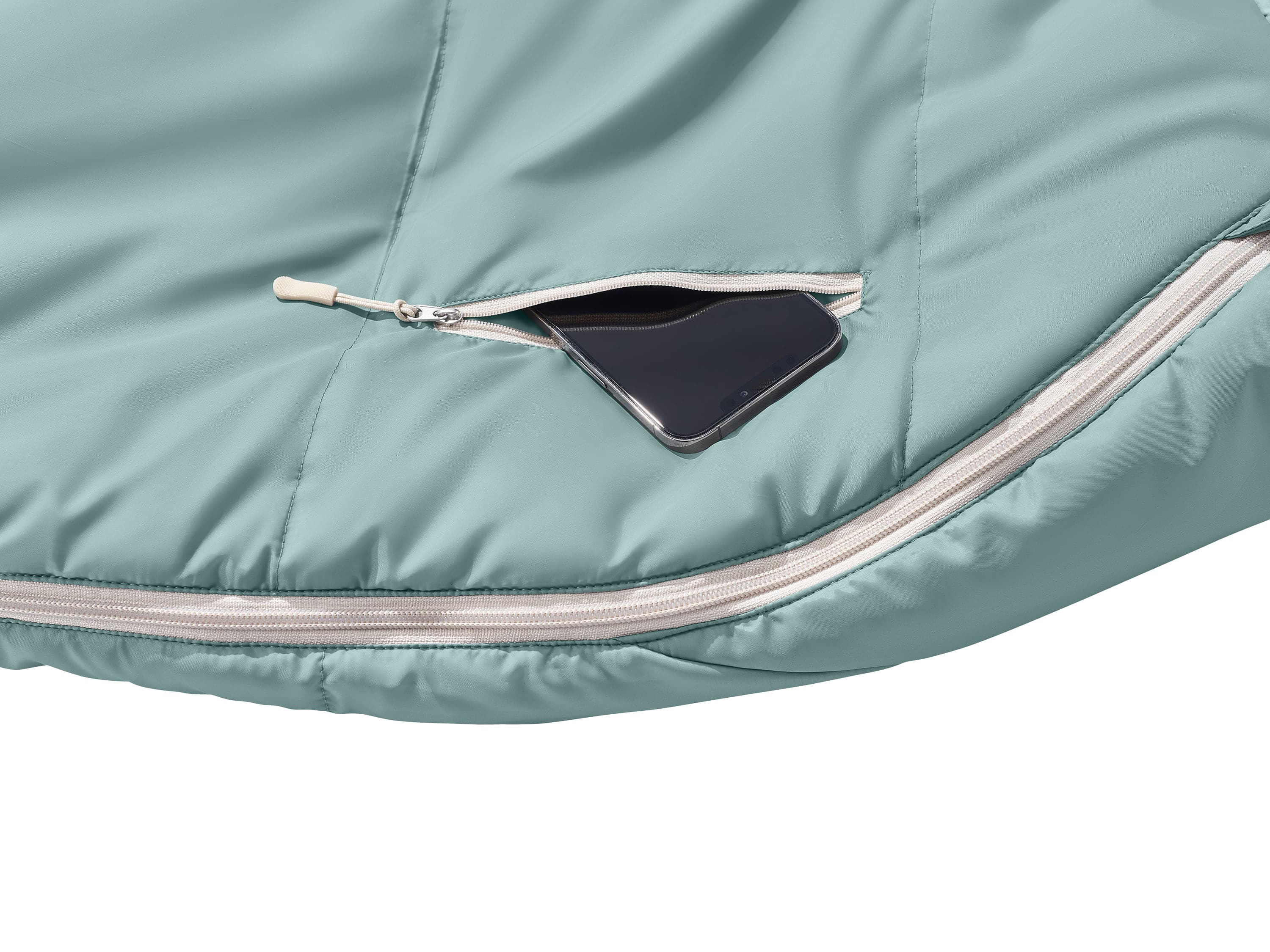 A close-up of a mint green fabric with a zipper pocket, showcasing a black smartphone nestled inside.