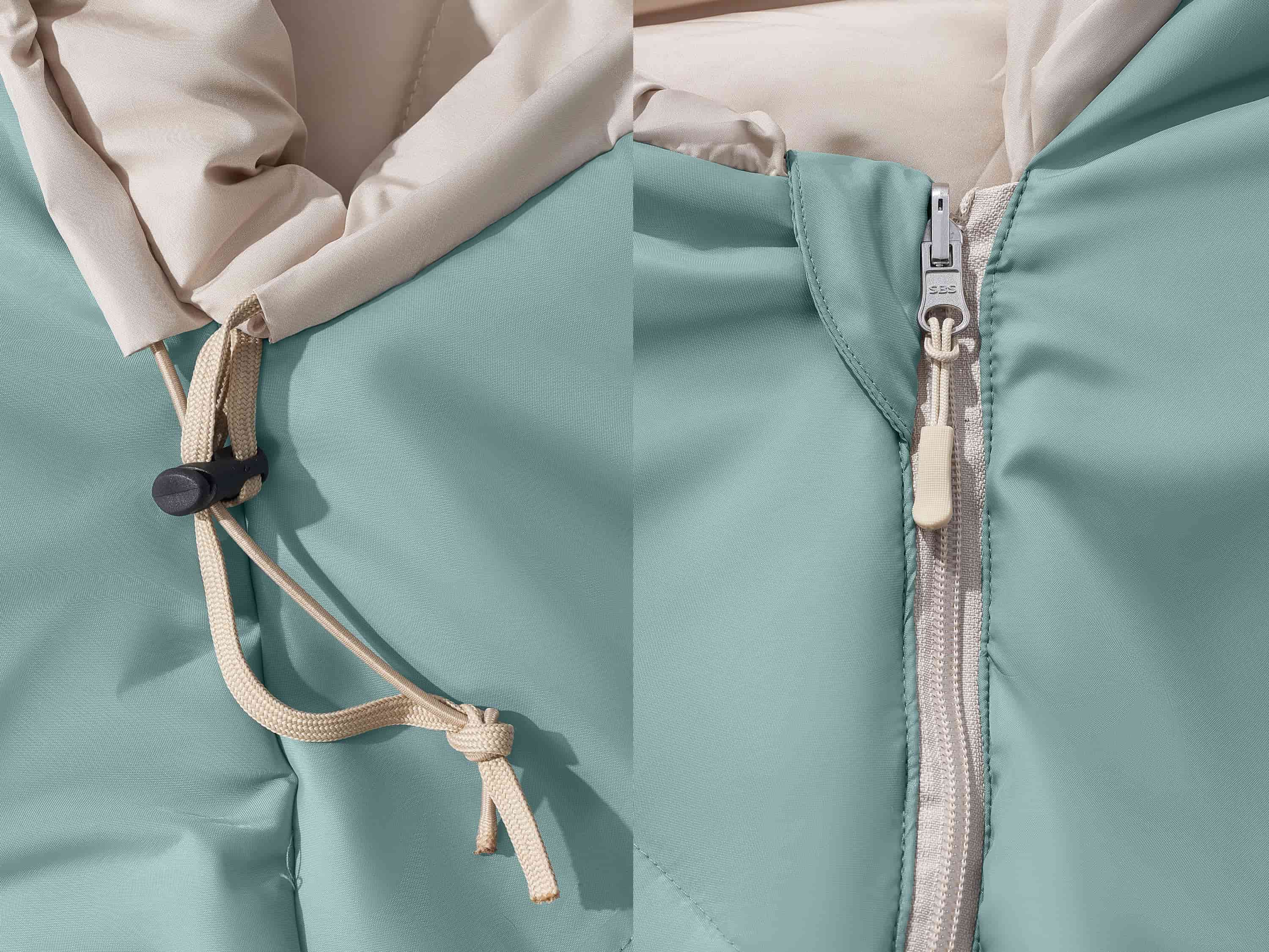 Close-up of a light teal sleeping bag closure showing a drawstring and a zipper with detailed stitching.