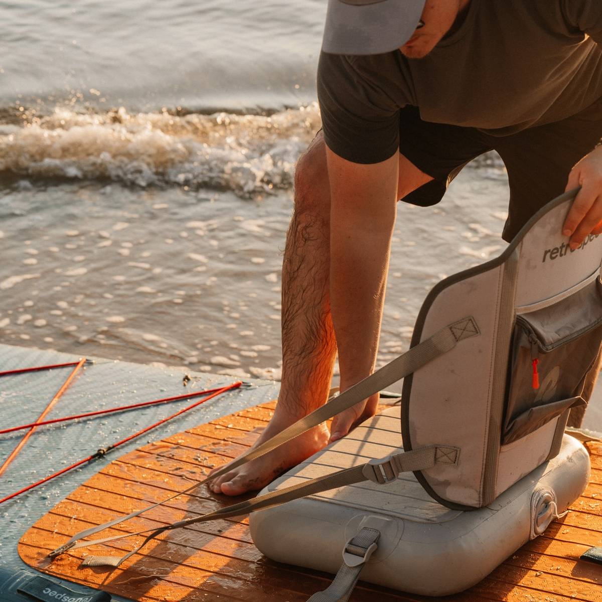 A man prepares an inflatable kayak seat on the Weekender Crew Inflatable Paddle Board.