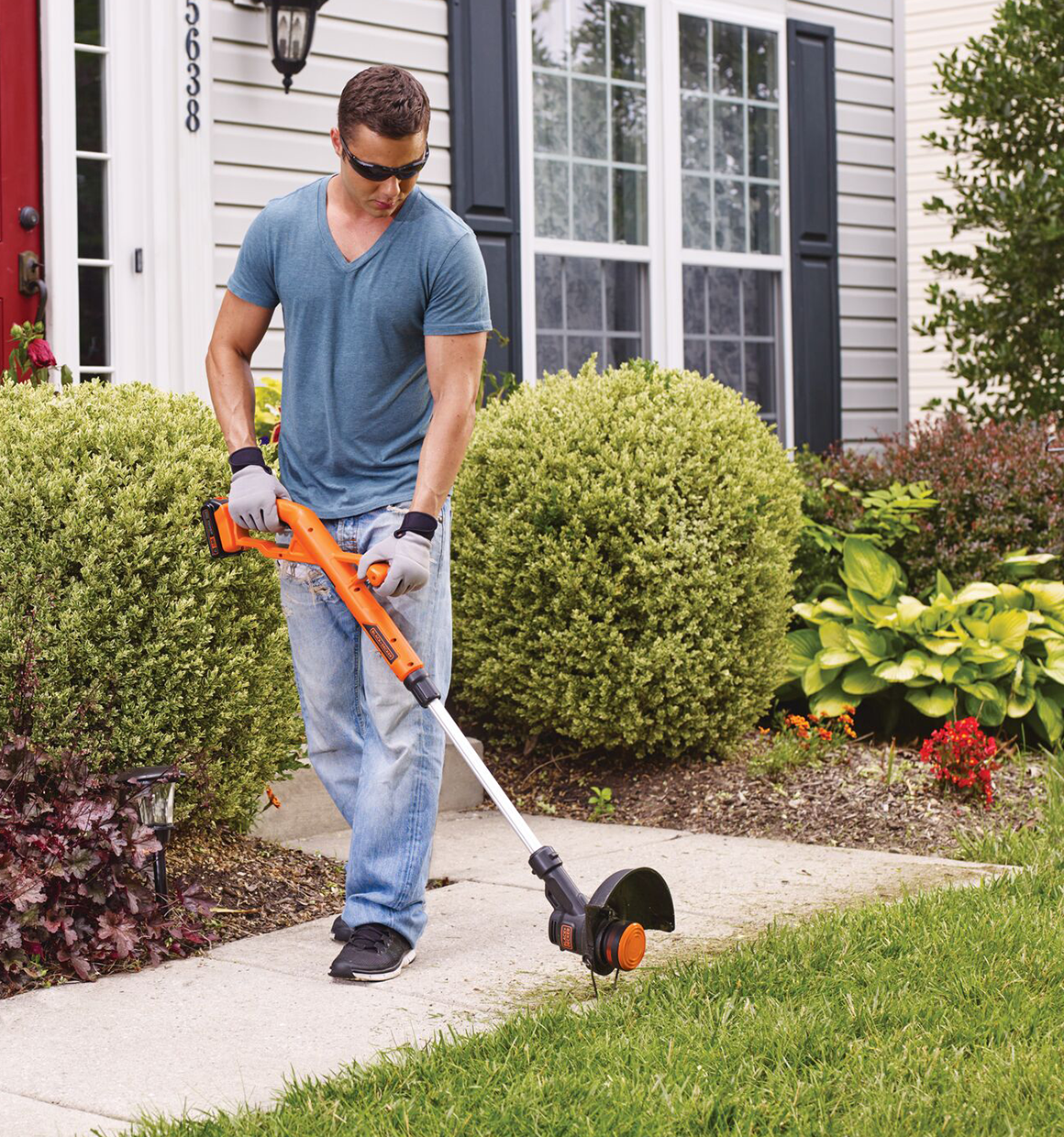 Person using Black and decker 20V Max* String Trimmer edging feature to edge a walkway.