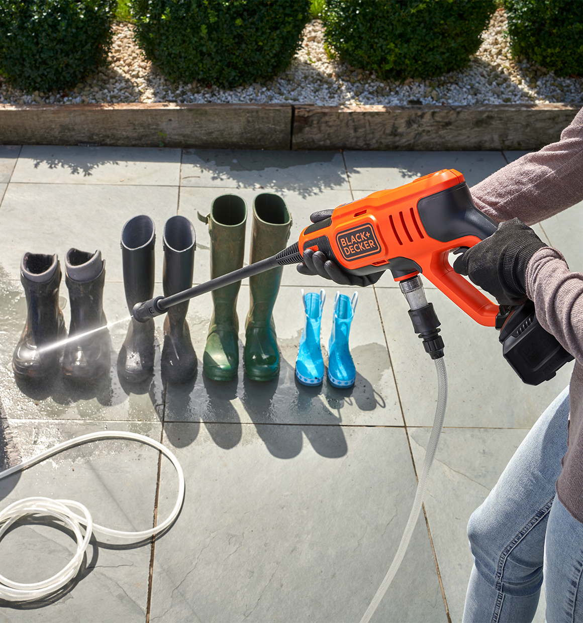20 Volt Cordless Power Cleaner Kit being used on garden boots.