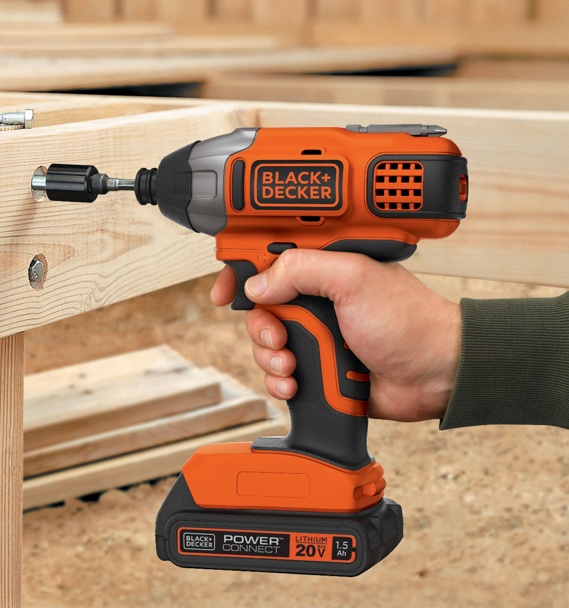 Close-up of an impact driver being used to drive a bolt into 2x4 framing.