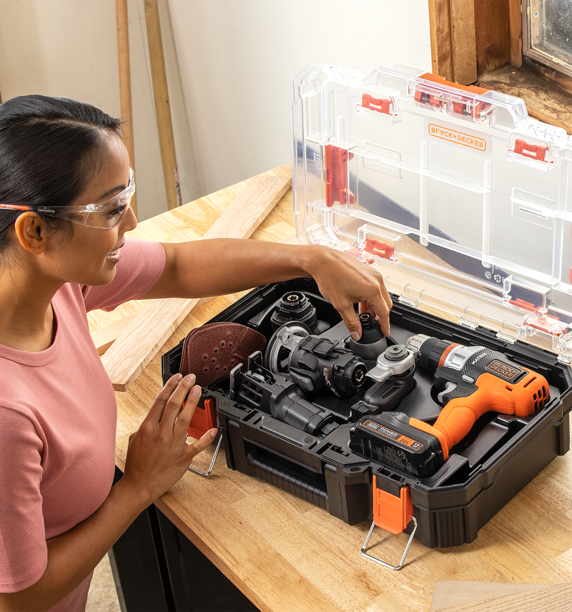 Woman opening the 20V Max Matrix Cordless Drill 6-Tool Combo Kit case to select a tool.