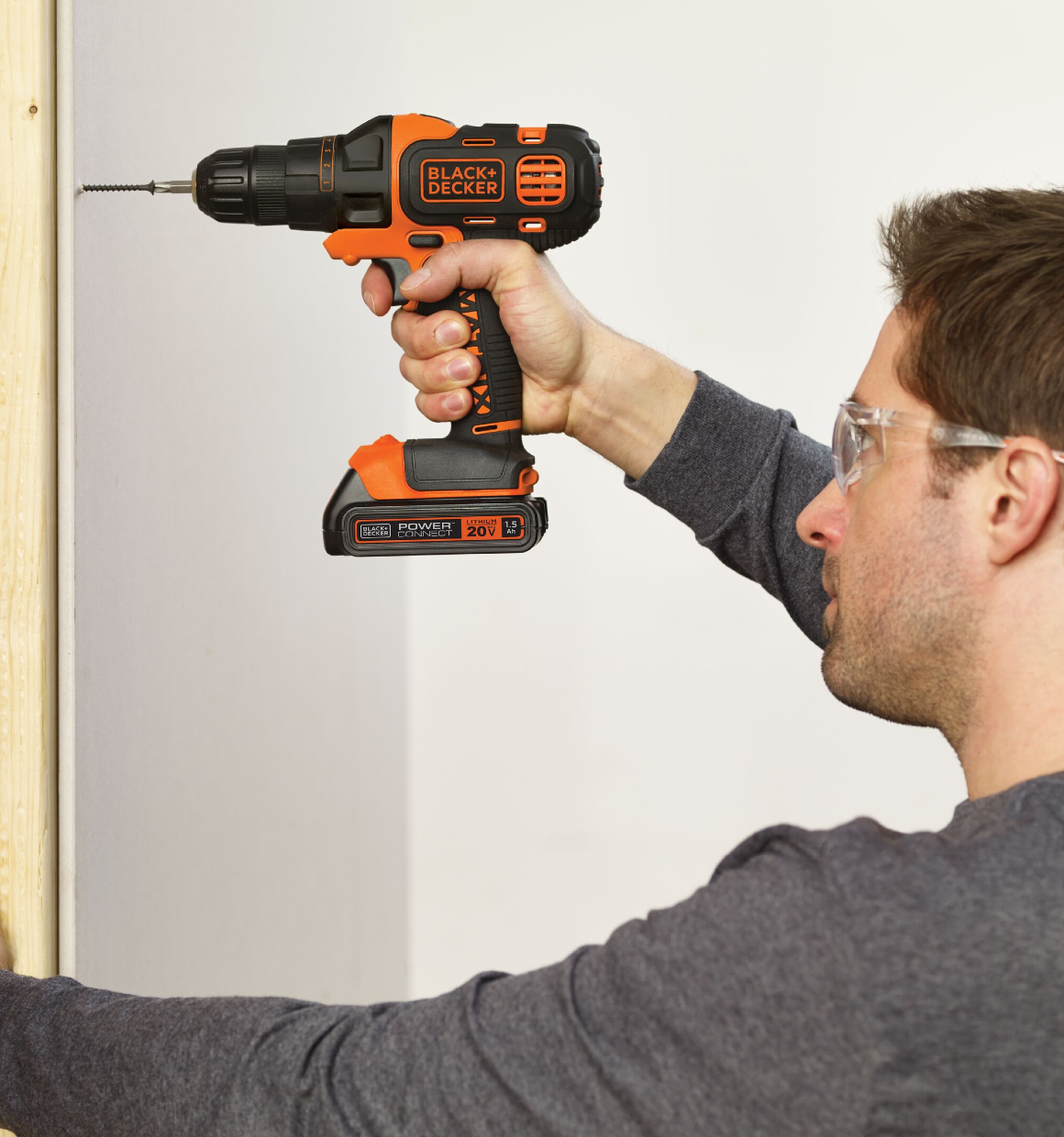 Person using MATRIX 20 Volt MAX Lithium Drill and Driver to drive a screw into drywall to connect it to wood.