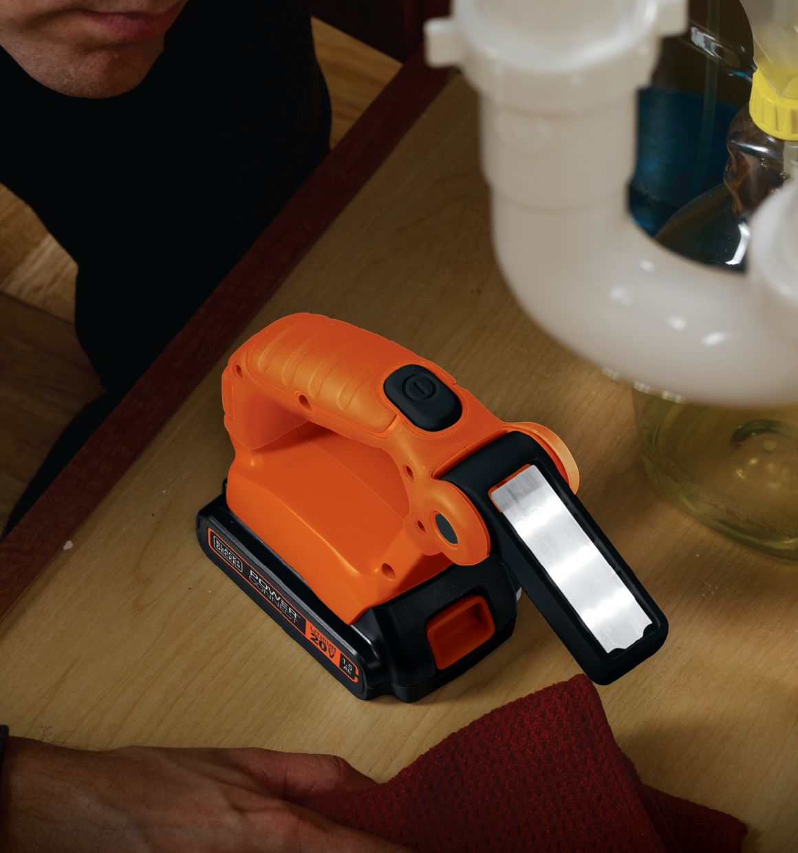 20 volt max lithium flashlight battery and charger not included being used by a person.