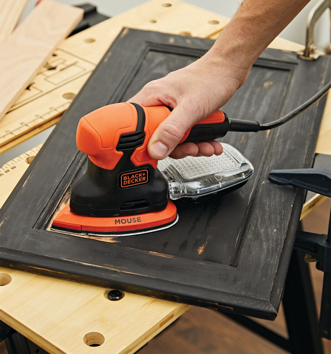 1.2 Amp mouse sander being used by a person to sand wooden frame.