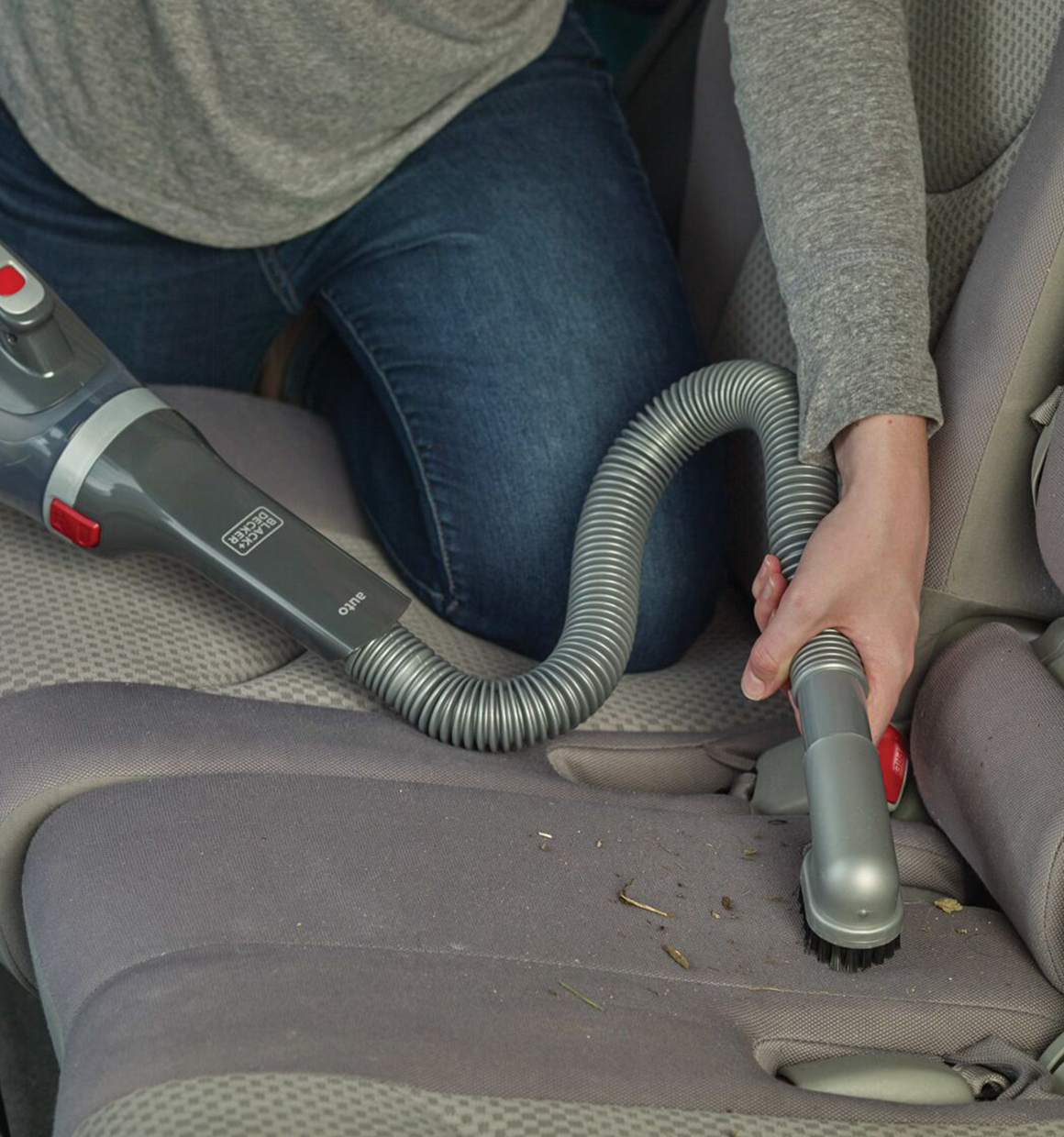 Dust buster Car Handheld Vacuum being used on car seat.