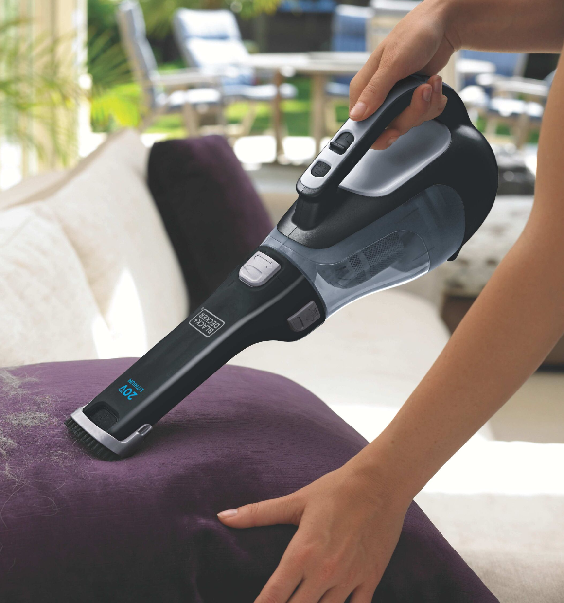 Close-up of Dustbuster Cordless Hand Vacuum being used to vacuum a seat cushion.
