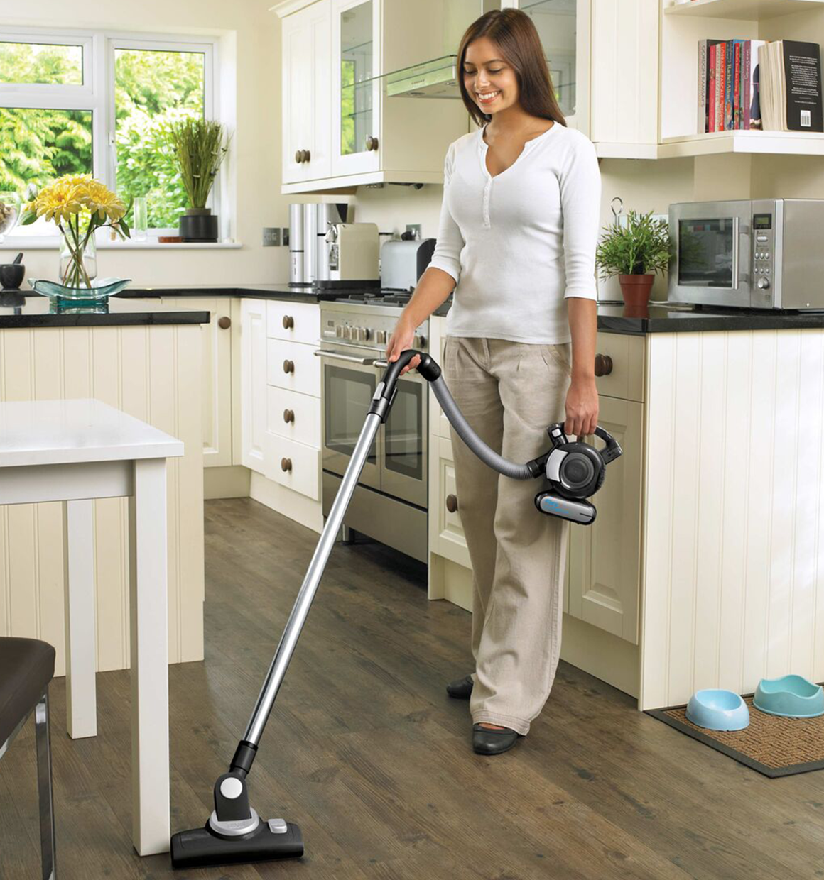 Dustbuster flex cordless hand vacuum with floor head and pet hair brush being used by a person.