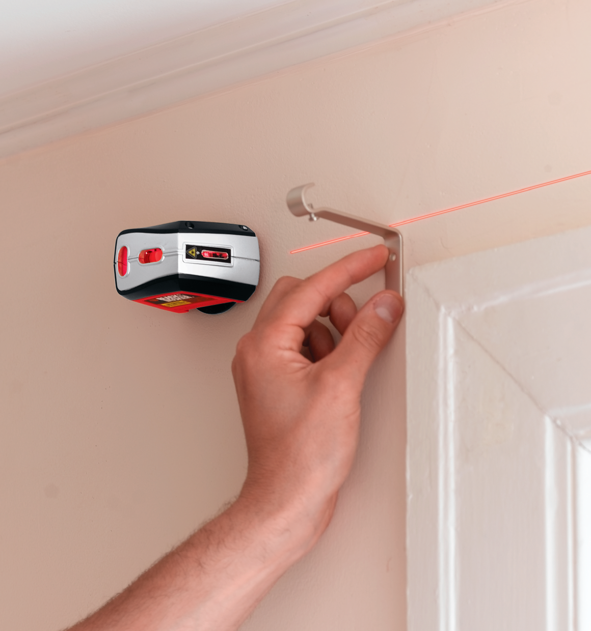 Laser level being used above window.