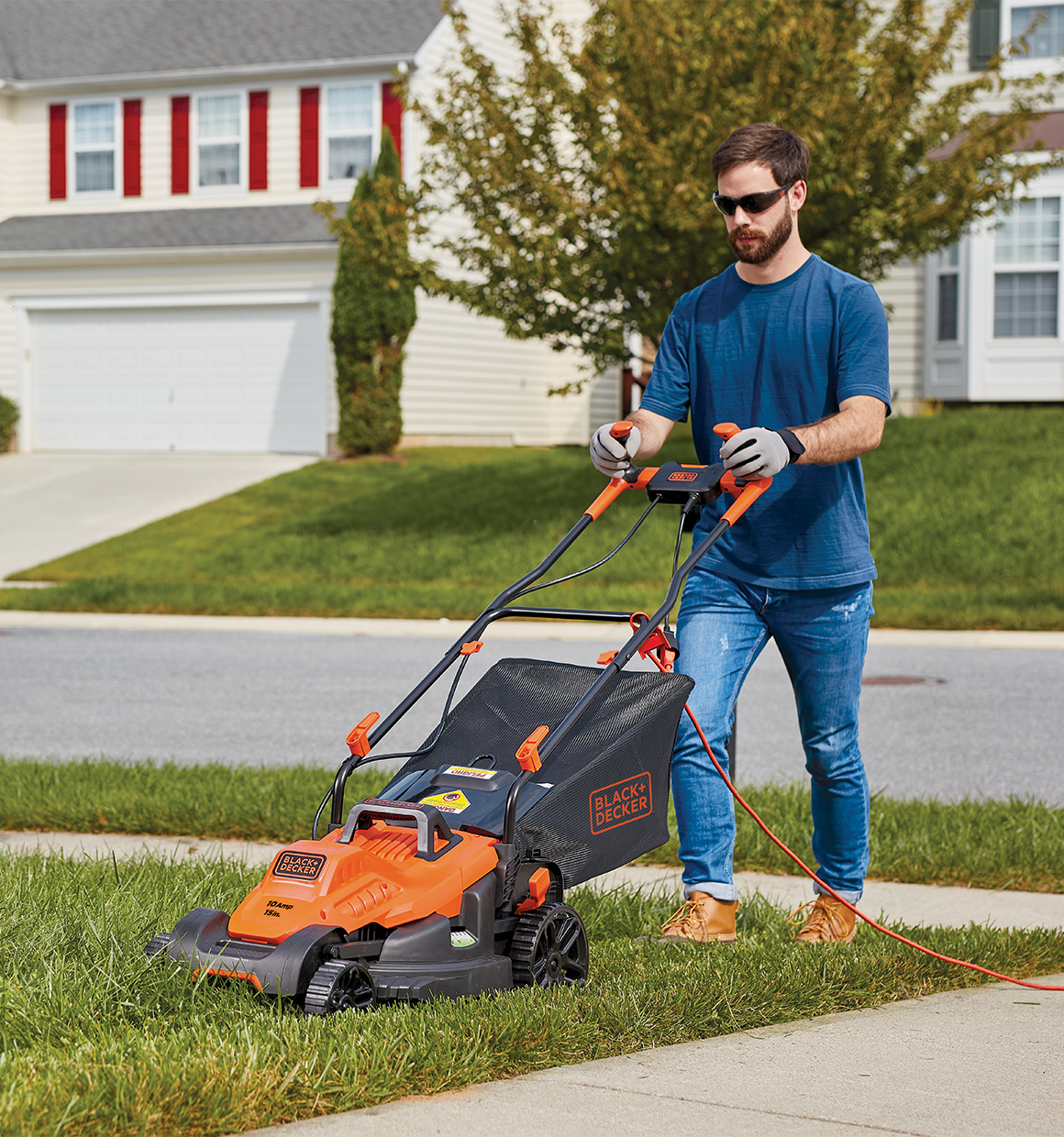 10 amp 15 inch electric lawn mower with comfort grip handle being used by a person.