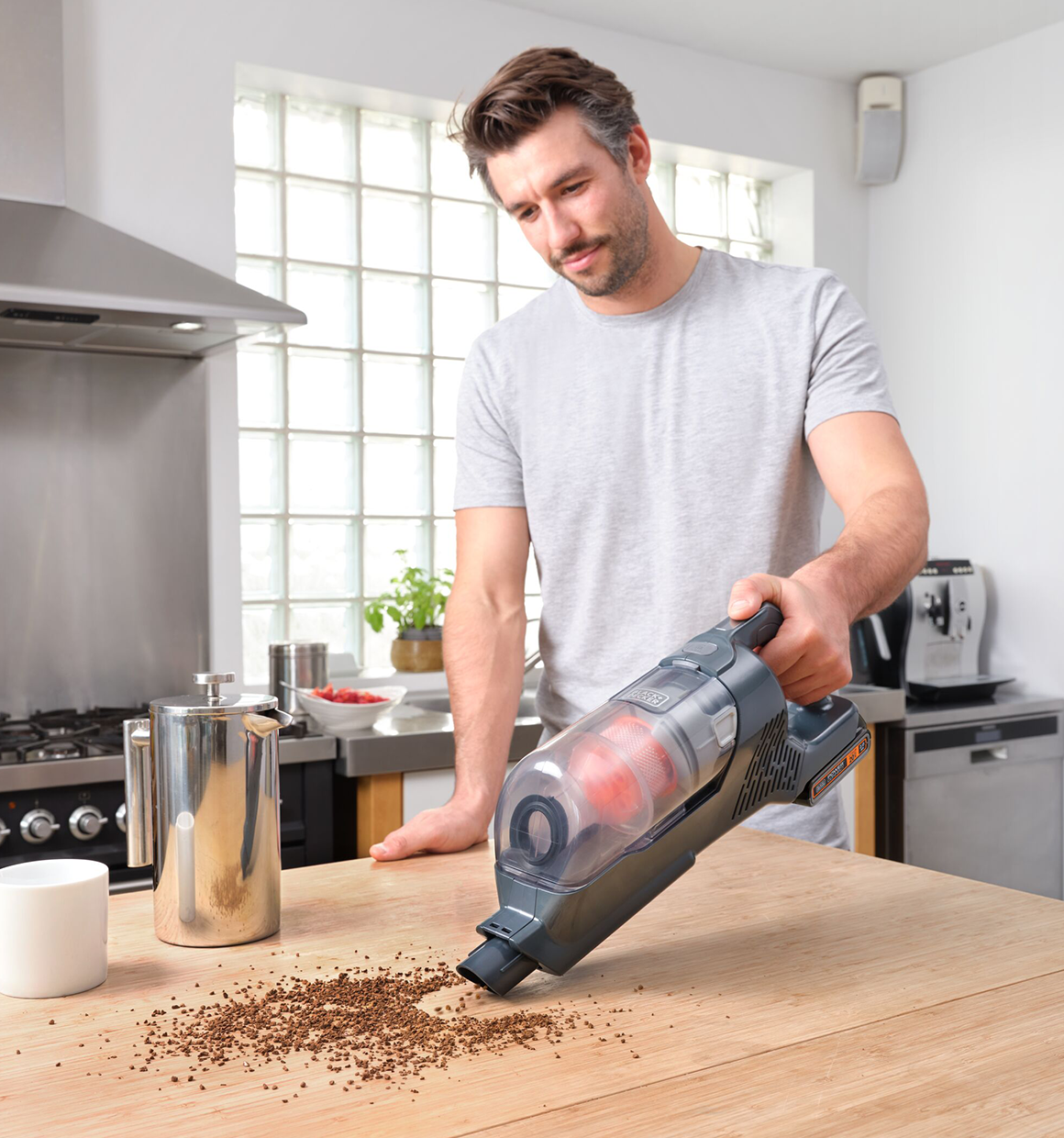 POWER SERIES plus Cordless Stick Vacuum being used to clean coffee powder from counter table.