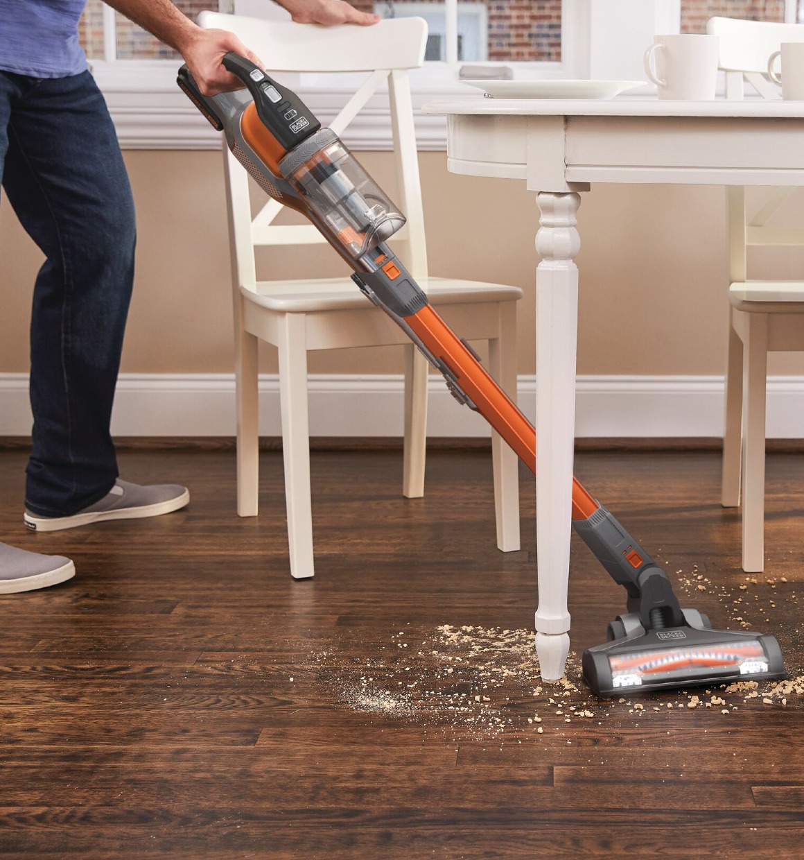 POWER SERIES Extreme Cordless Stick Vacuum Cleaner being used for cleaning mess under dining table.