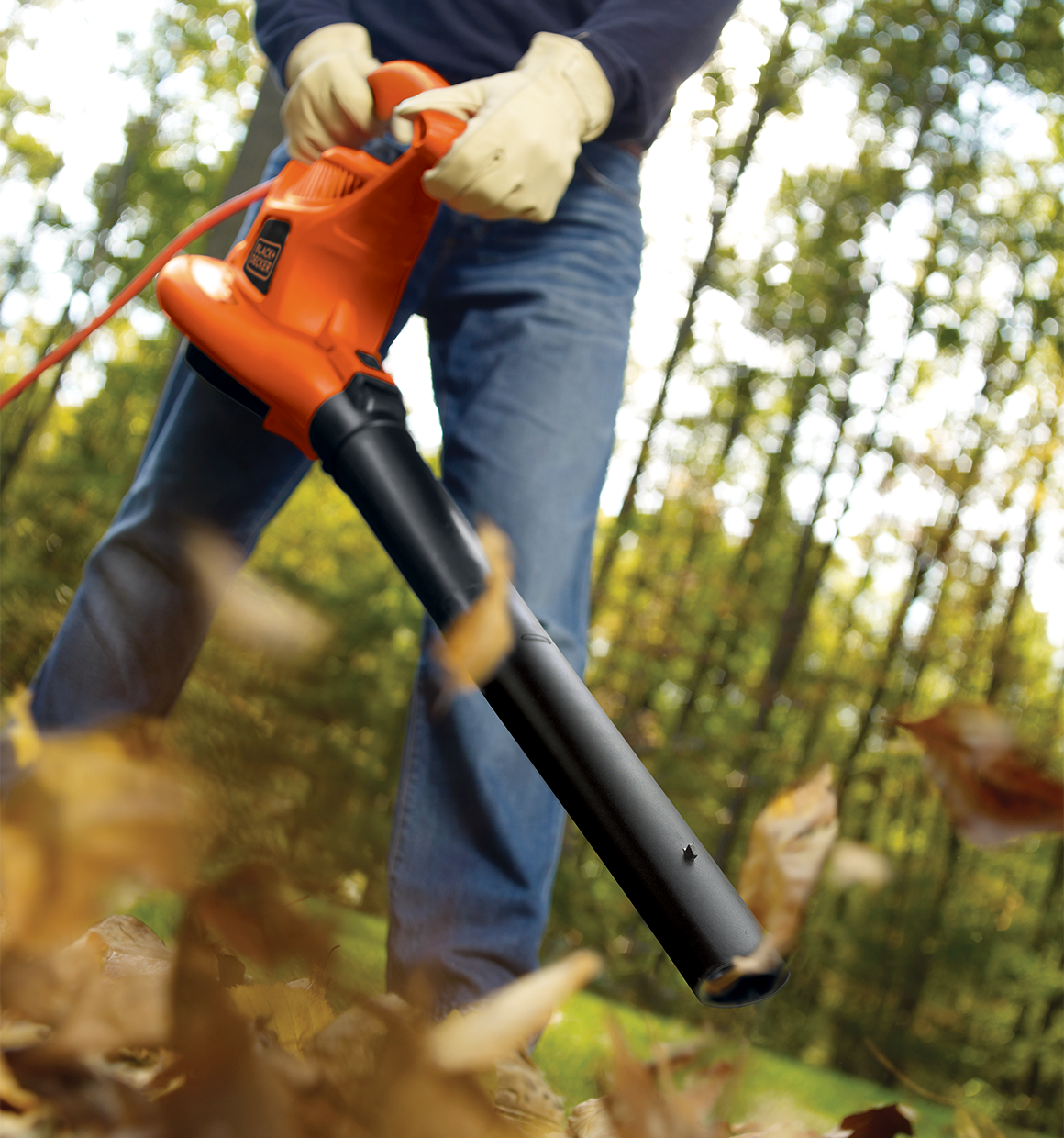 High performance blower / vacuum / mulcher being used by a person to clear leaves.