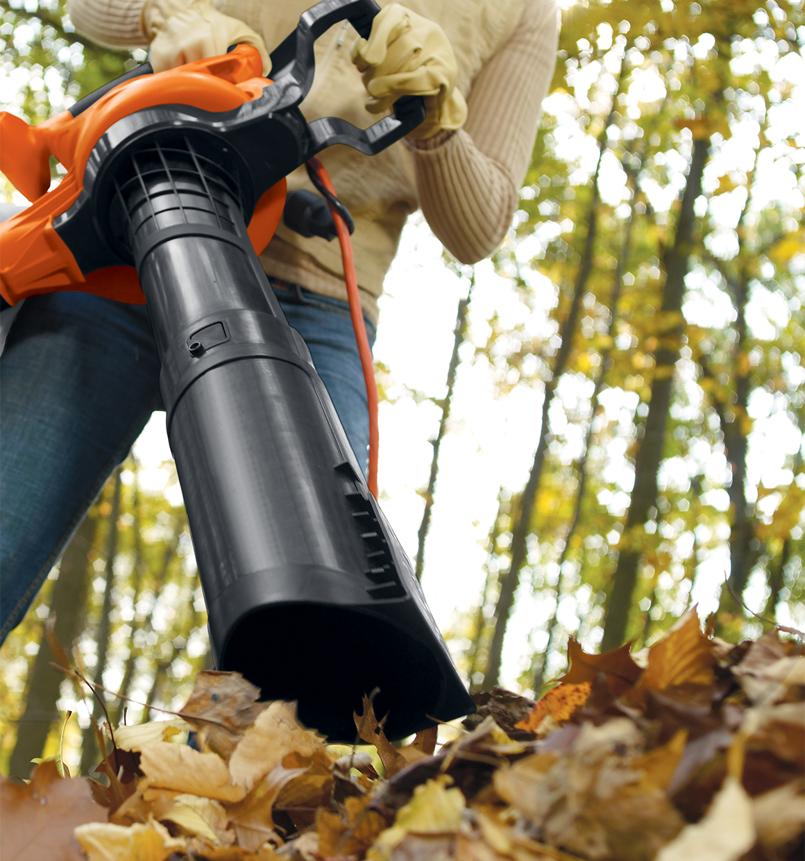 High performance blower / vacuum / mulcher being used by a person to clear leaves.