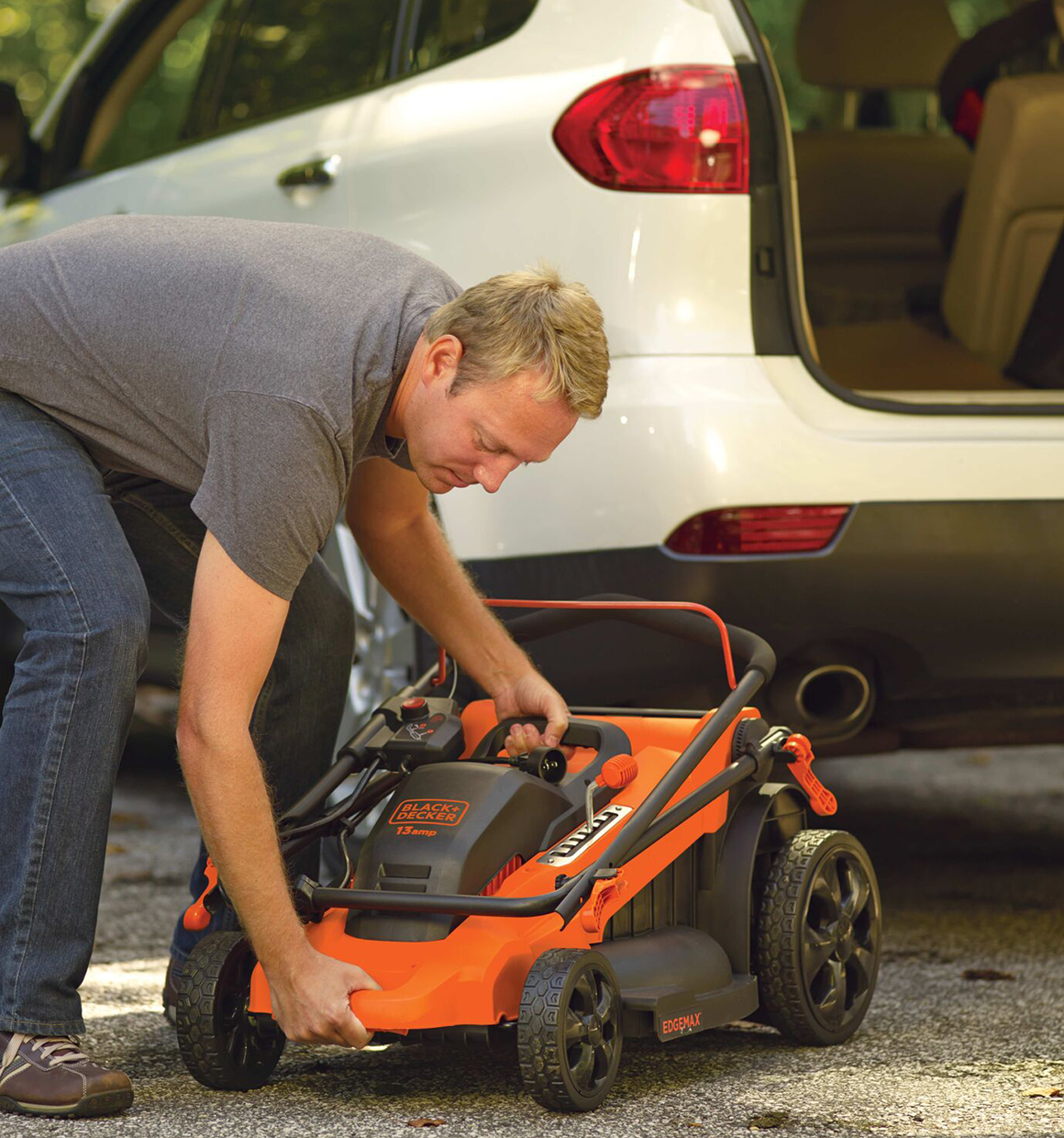 Black and Decker 40 volt MAX Lithium Ion 20 inch Mower being folded up by a person.