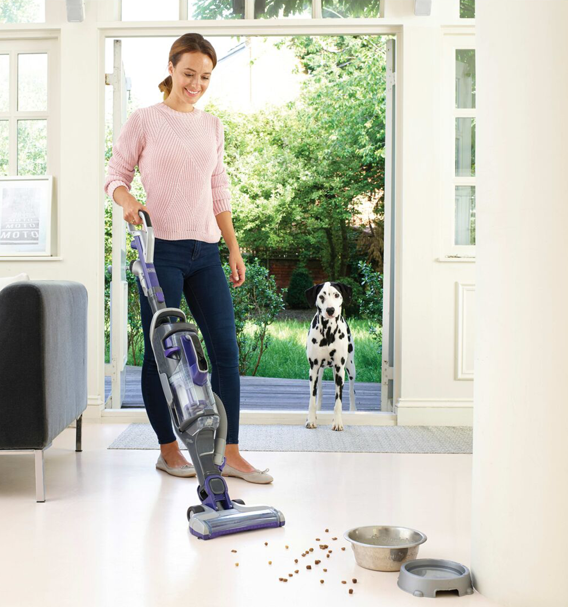 Black and decker powerseries pro cordless 2 in 1 pet vacuum being used to clean up spilled pet food from a floor.