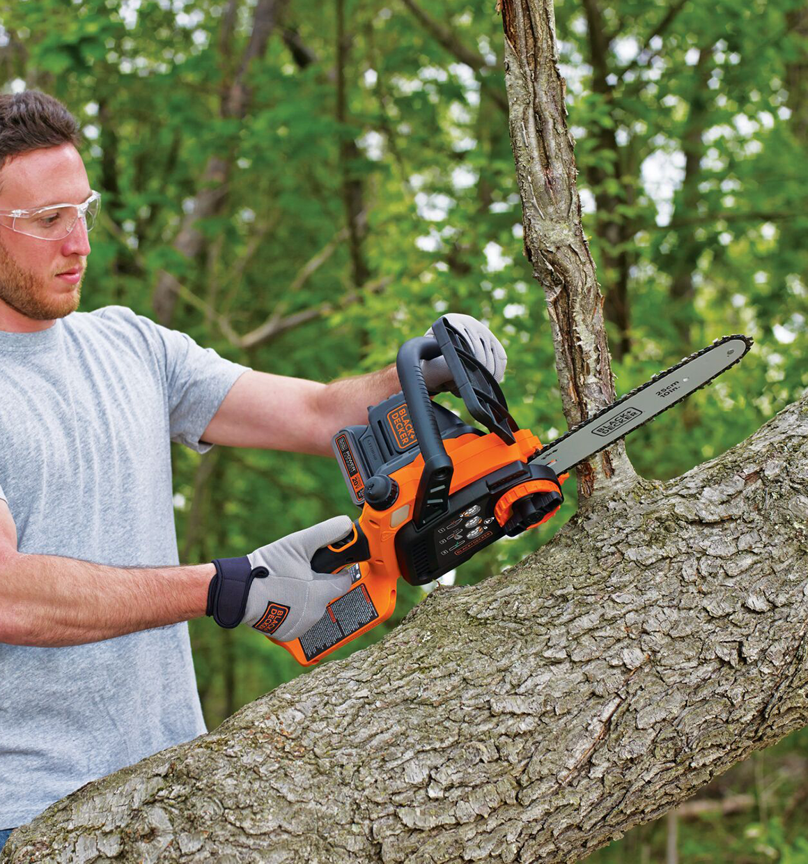 Person using Black and Decker 20V Max* Cordless Chainsaw, 10-Inch to cut a tree branch.