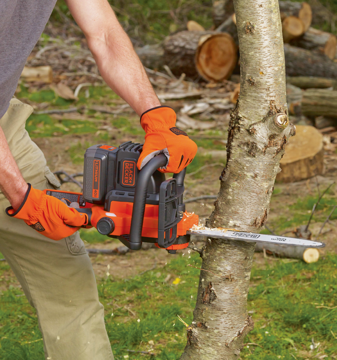 40 volt MAX Lithium 12 inch Chainsaw being used to cut down a tree by a person.