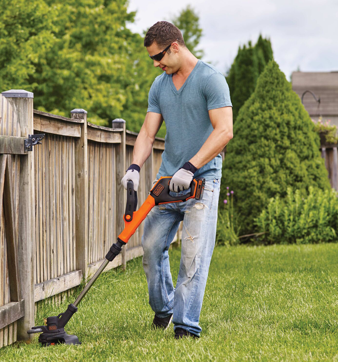 Lithium 12 inch 2 speed string trimmer / edger being used by a person to trim grass.