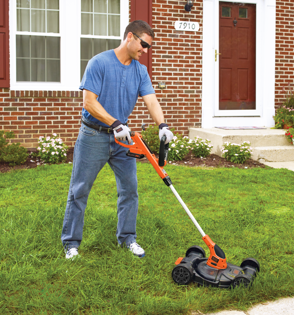 20 volt MAX lithium 12 inch 3 in 1 compact mower being used by a person to trim grass.