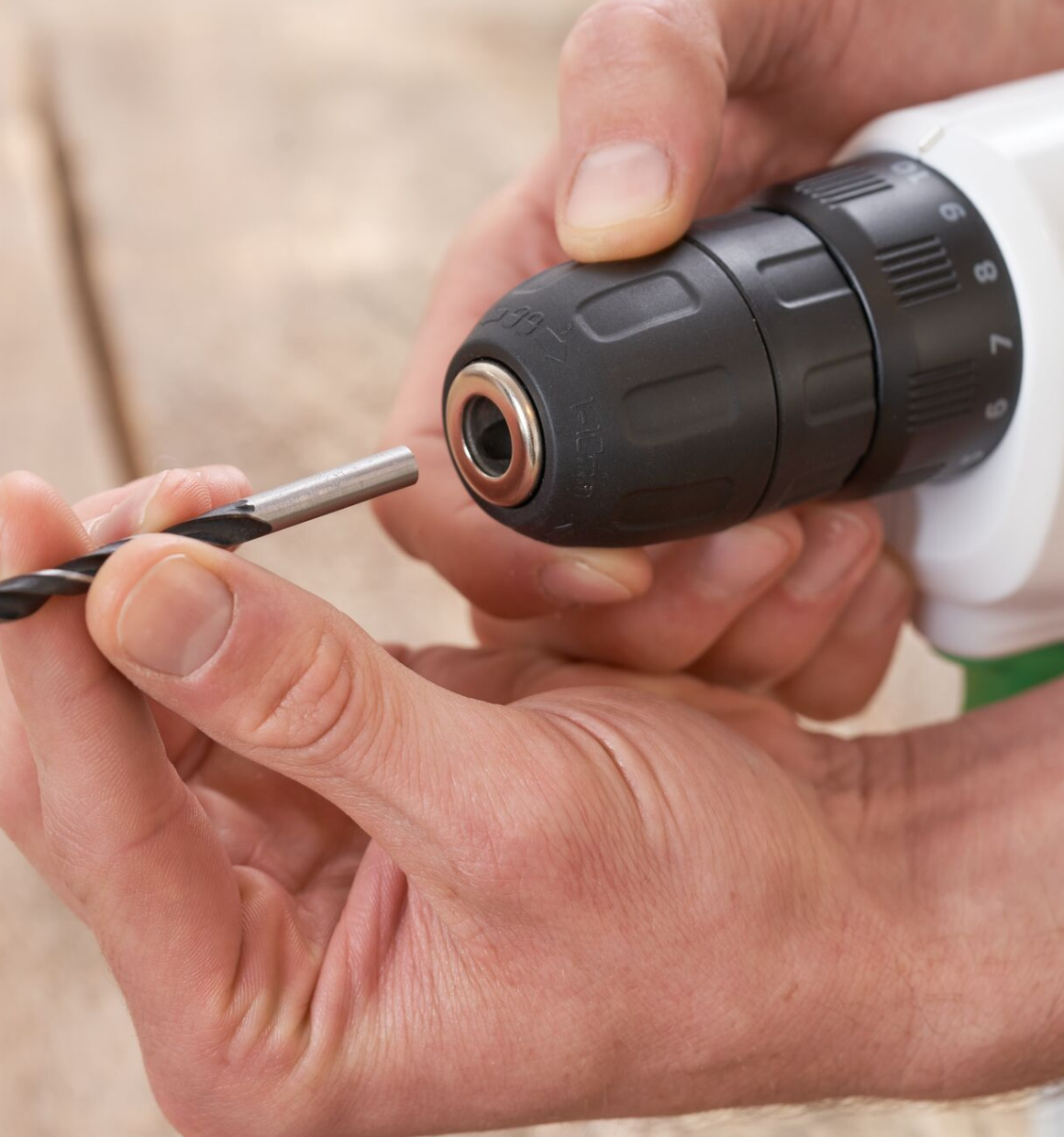 Close-up of someone inserting a drill bit into the chuck of a Reviva 12V Drill.