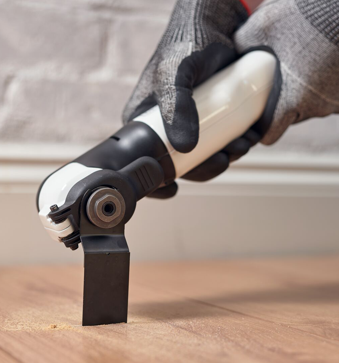 Reviva 12V Oscillating Multitool cutting into a wood floor.