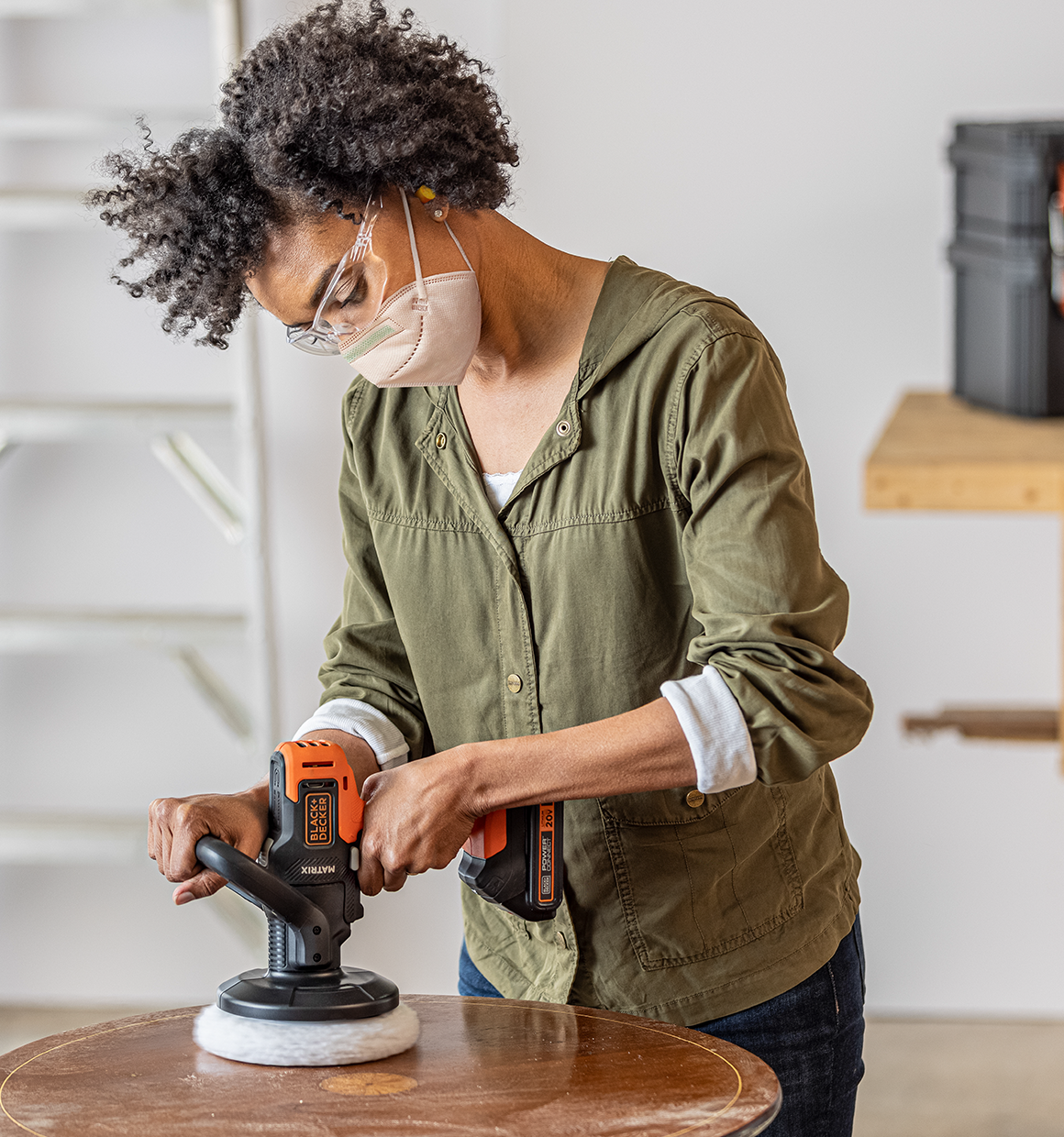 Woman using a 20V Max Matrix Buffer on a wooden tabletop.